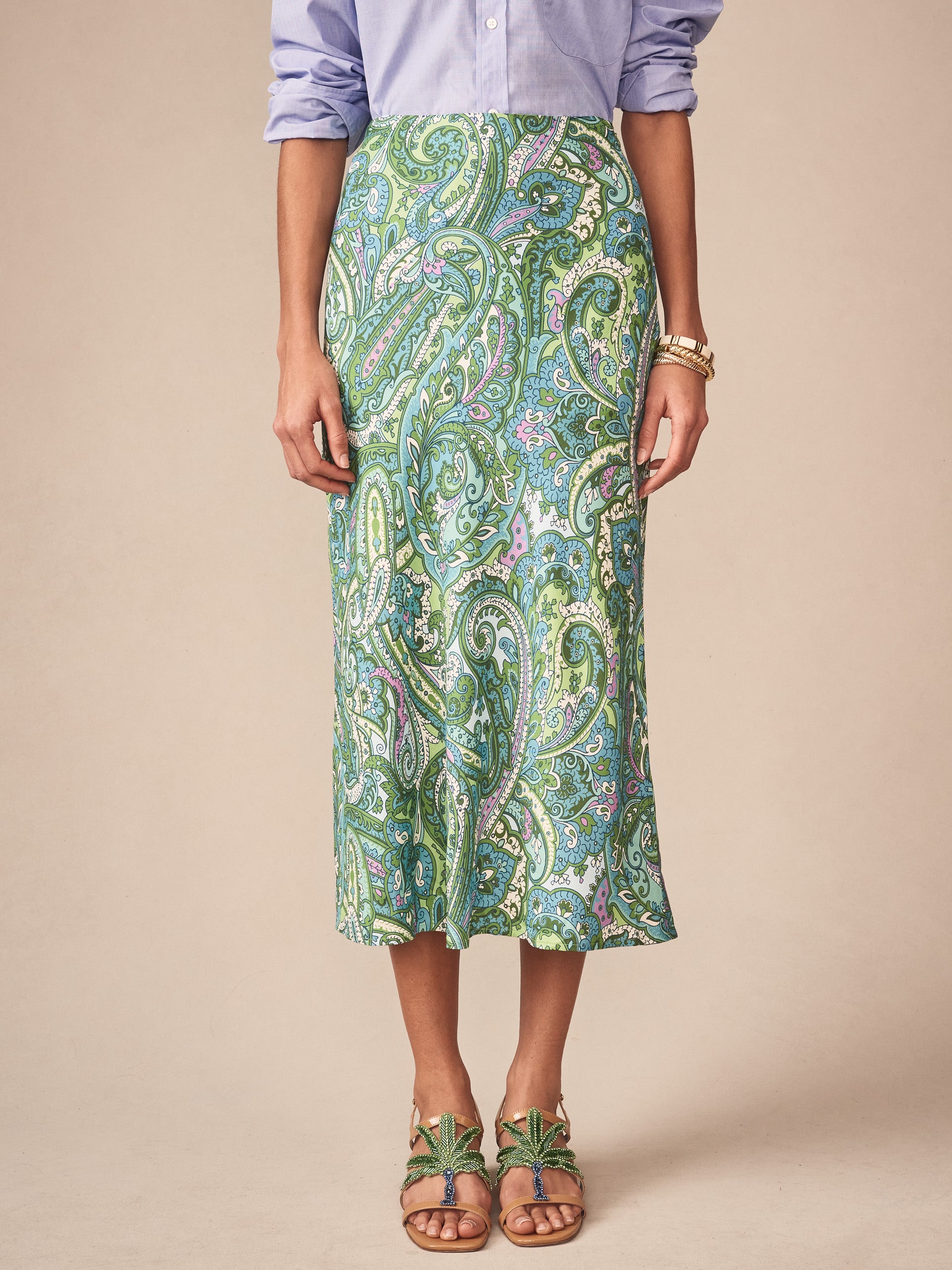 A model wears the Adelyn Skirt in Paisley Reverie Bias by J.McLaughlin, featuring an effortlessly stylish paisley print skirt in green and blue tones, exemplifying enduring designs and innovative fabrics. A destination for defining style. Life, Well-Lived.