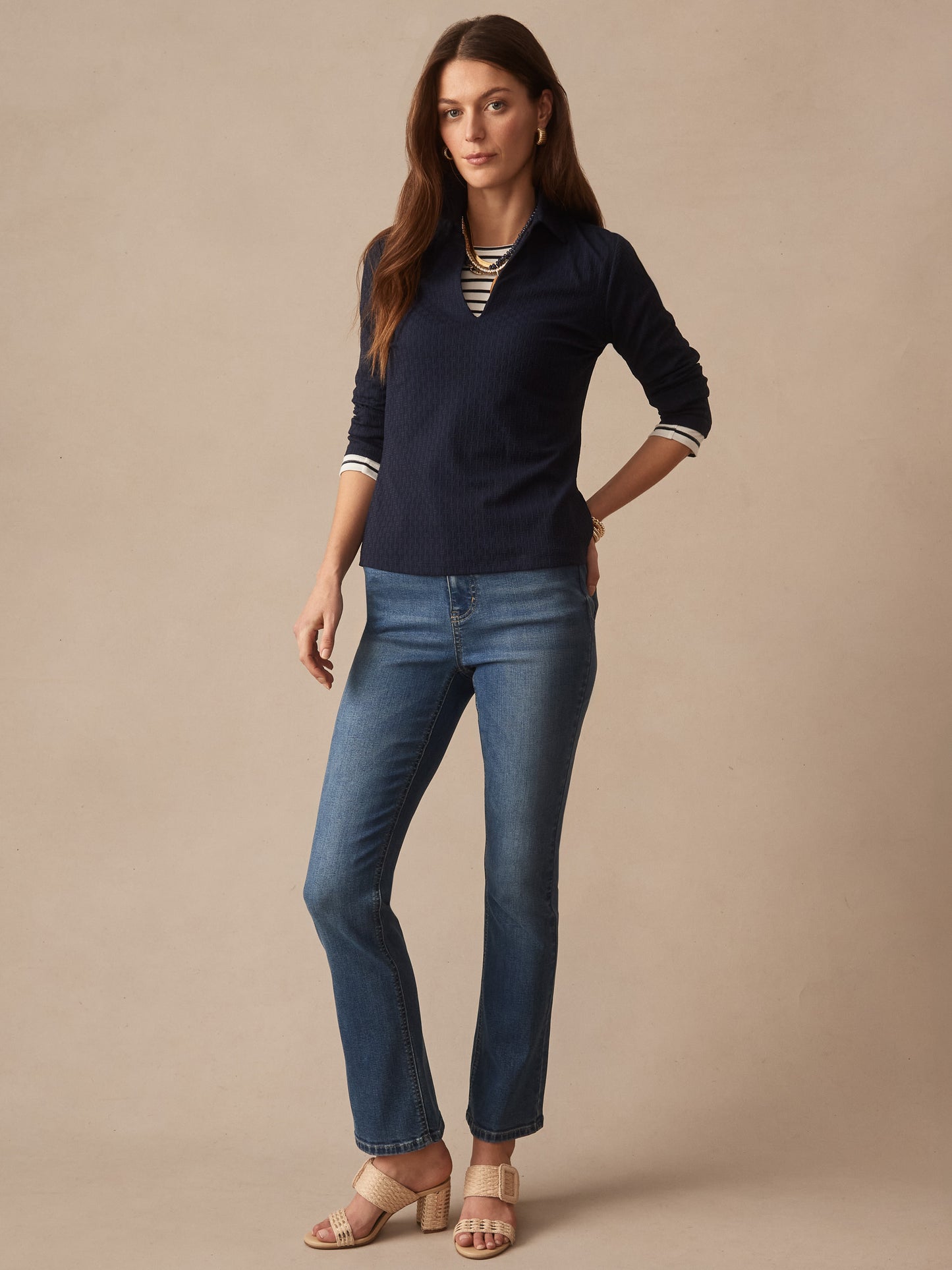 Model wearing Aida 3/4 Sleeve Top in Dashing Jacquard by J.McLaughlin in navy, paired with jeans and beige sandals, showcasing effortlessly stylish, enduring designs.