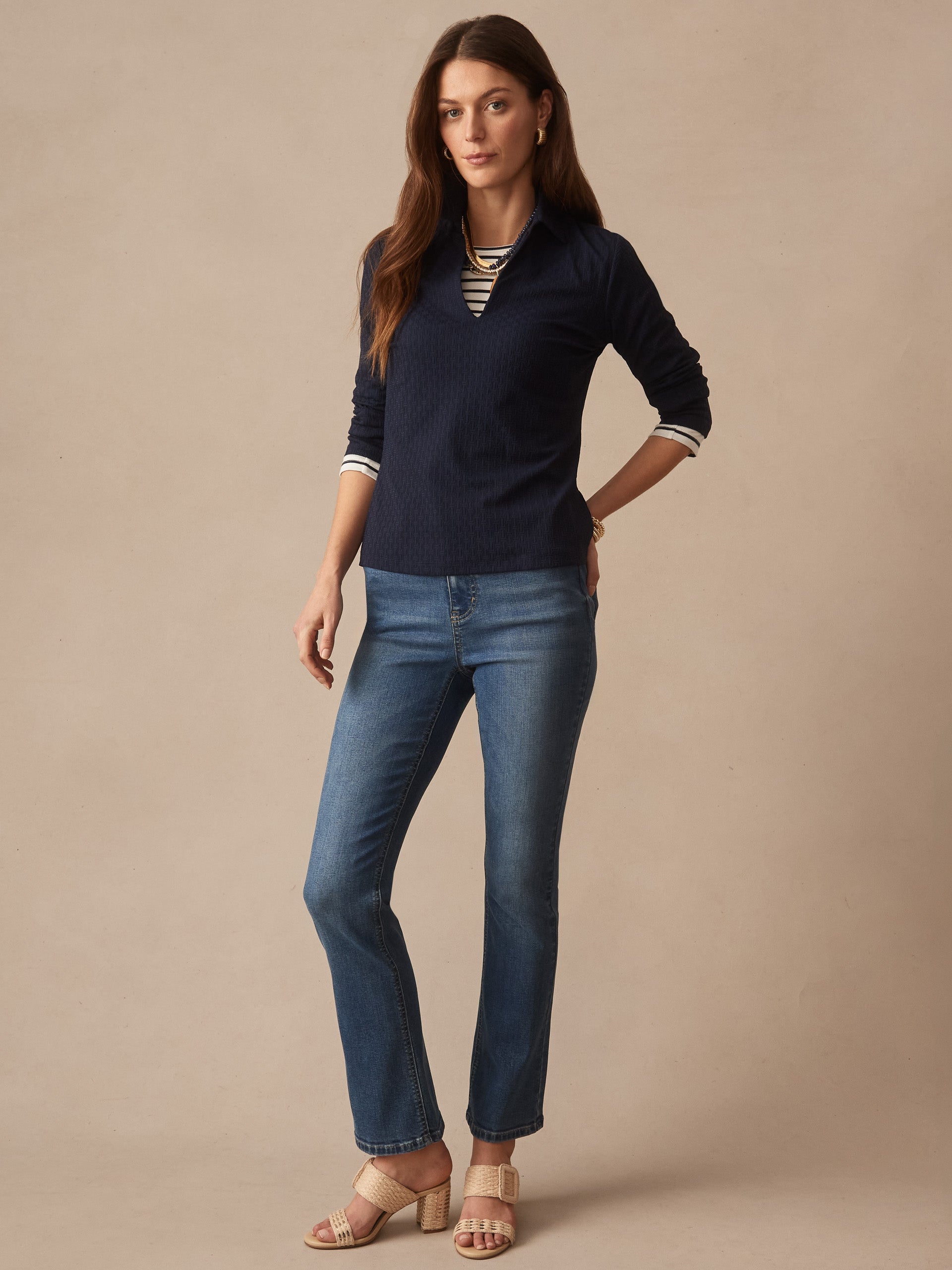 Model wearing Aida 3/4 Sleeve Top in Dashing Jacquard by J.McLaughlin in navy, paired with jeans and beige sandals, showcasing effortlessly stylish, enduring designs.