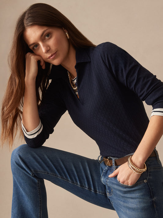 Woman wearing a navy Aida 3/4 Sleeve Top in Dashing Jacquard by J.McLaughlin, paired with jeans and gold jewelry, showcasing effortlessly stylish, enduring designs.