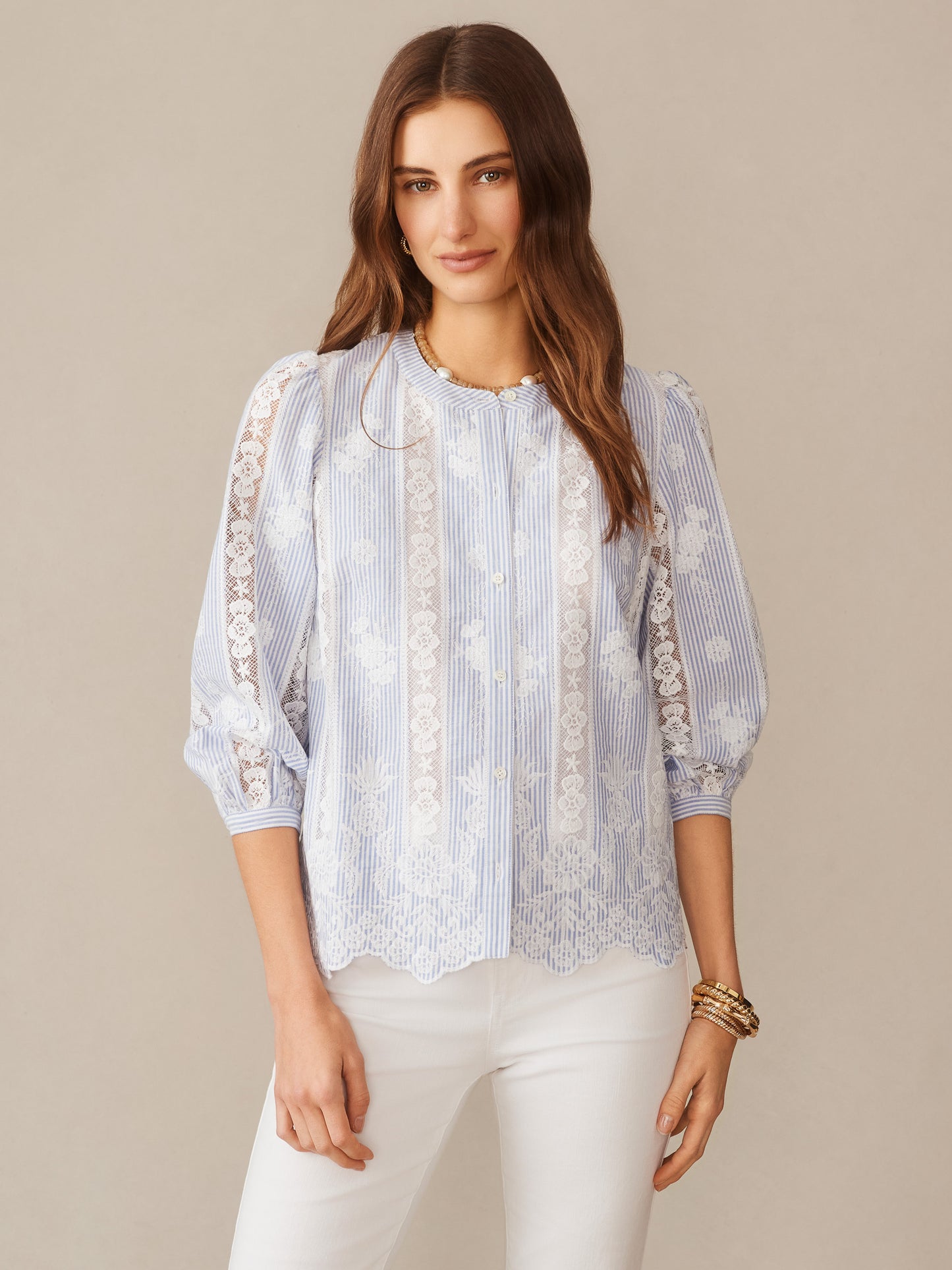 A woman wears the Alice Blouse in Stripe by J.McLaughlin, featuring delicate lace detailing and soft blue stripes, embodying effortlessly stylish, enduring designs for a legacy of timeless fashion. A destination for defining style. Life, Well-Lived.