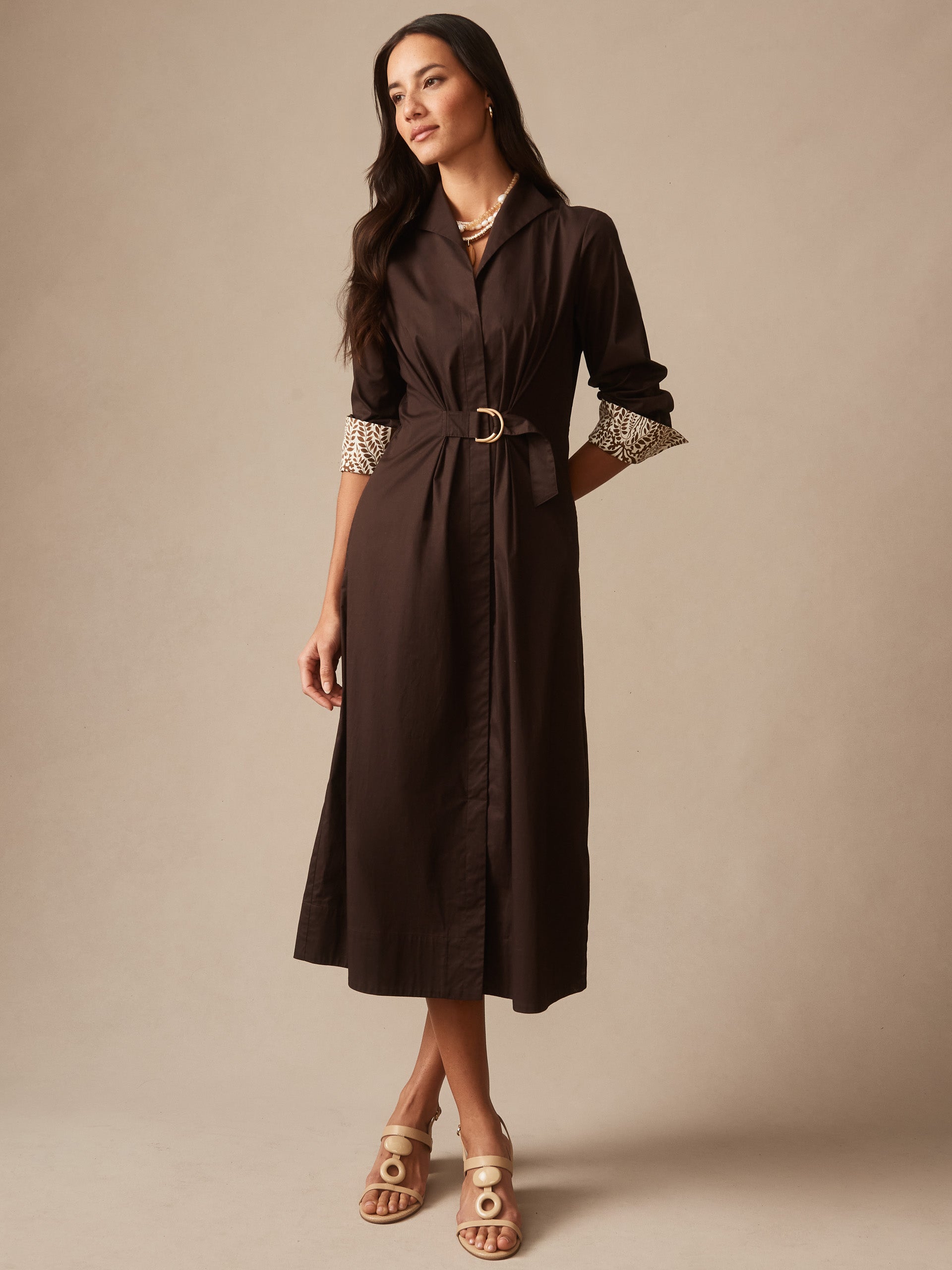 Woman wearing a chocolate brown Alina Dress by J.McLaughlin featuring a belted waist and patterned cuffs, showcasing effortlessly stylish and enduring designs in timeless fashion.