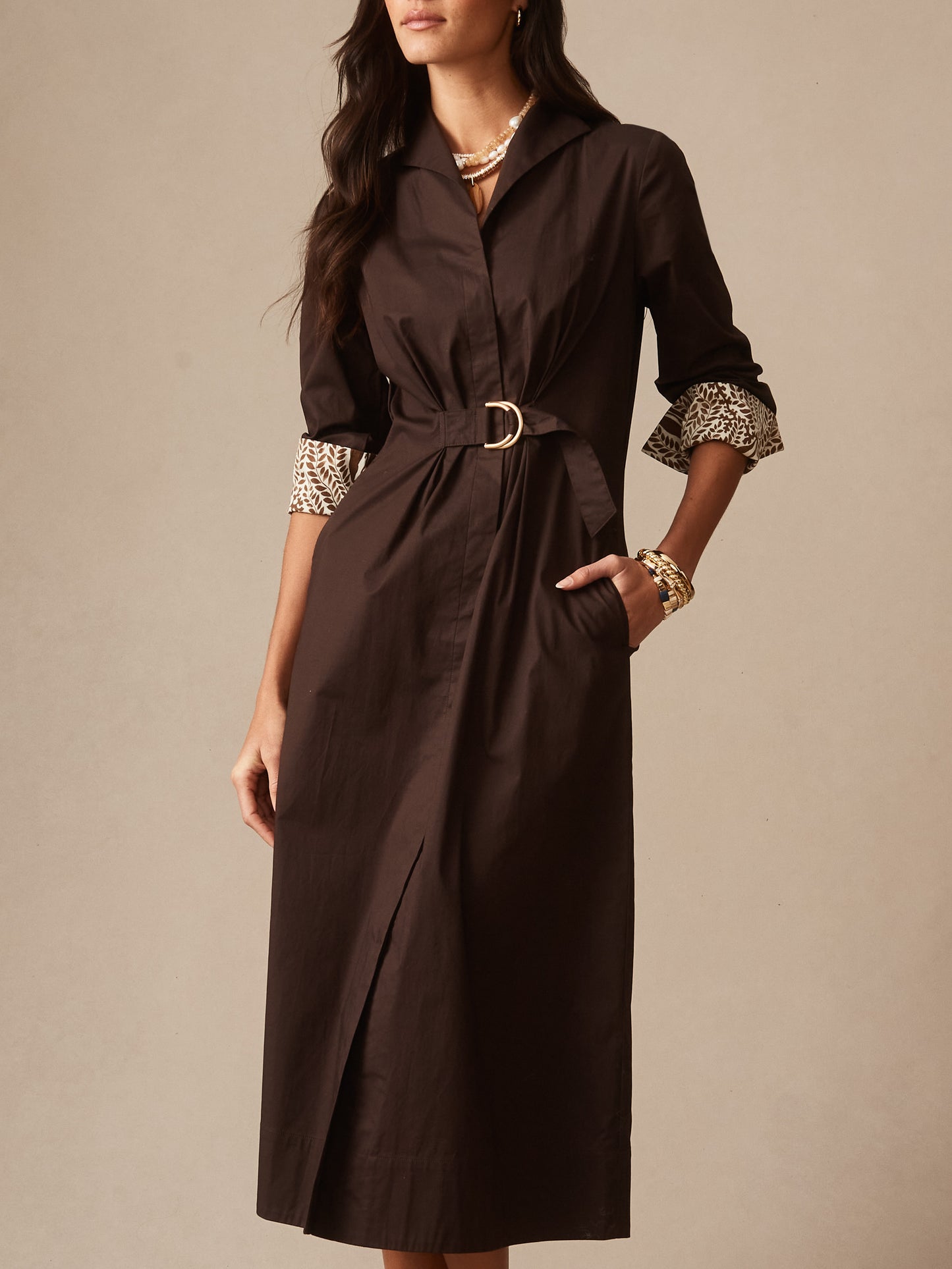Woman wearing Alina Dress by J.McLaughlin, featuring a rich chocolate tone, belted waist, and rolled sleeves with patterned lining, embodying effortlessly stylish, enduring designs.