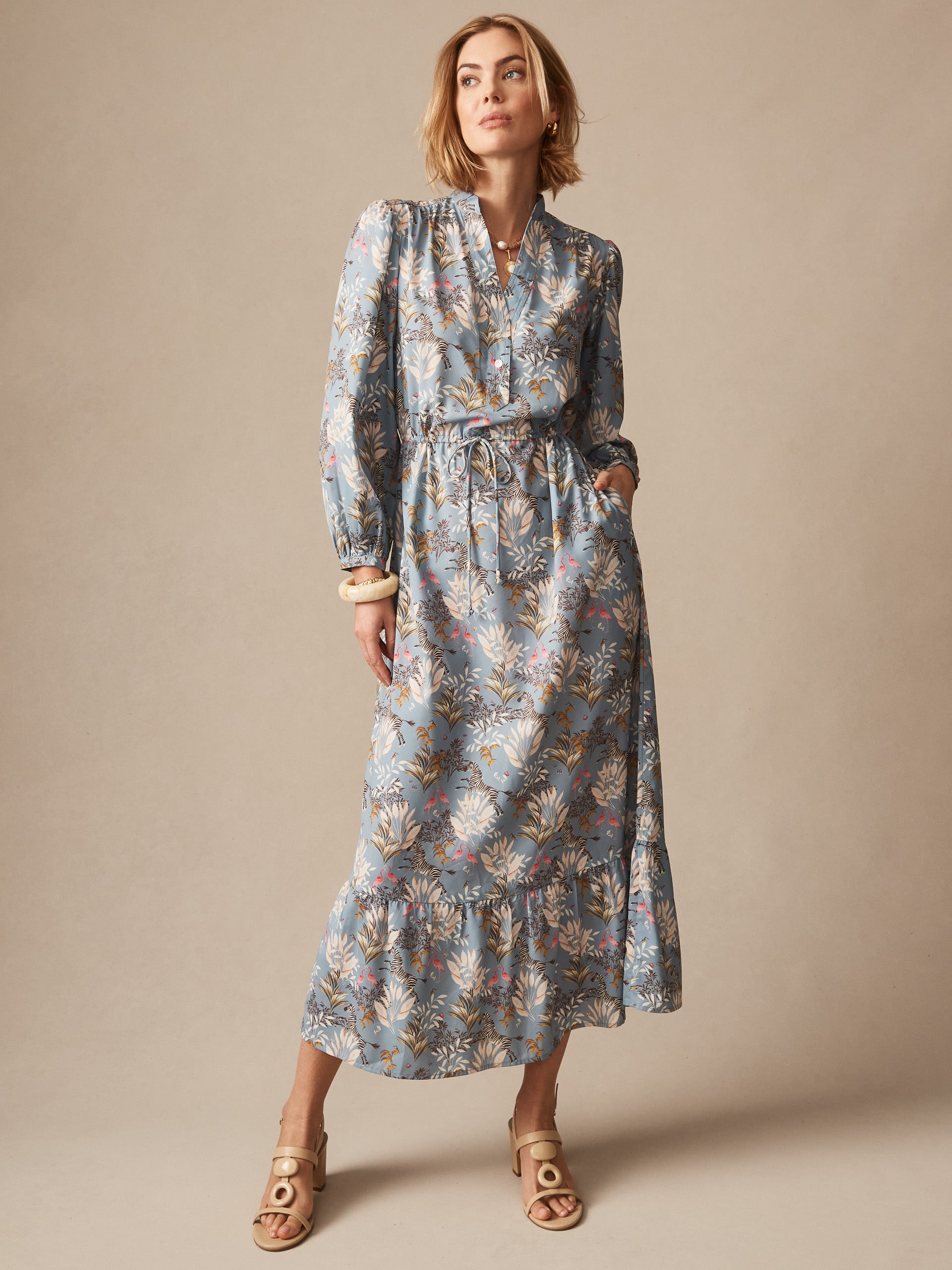Woman wearing the Amrita Dress in Zebra Story by J.McLaughlin, featuring a floral pattern with long sleeves and a flowing silhouette, showcasing effortlessly stylish, enduring designs and innovative fabrics.