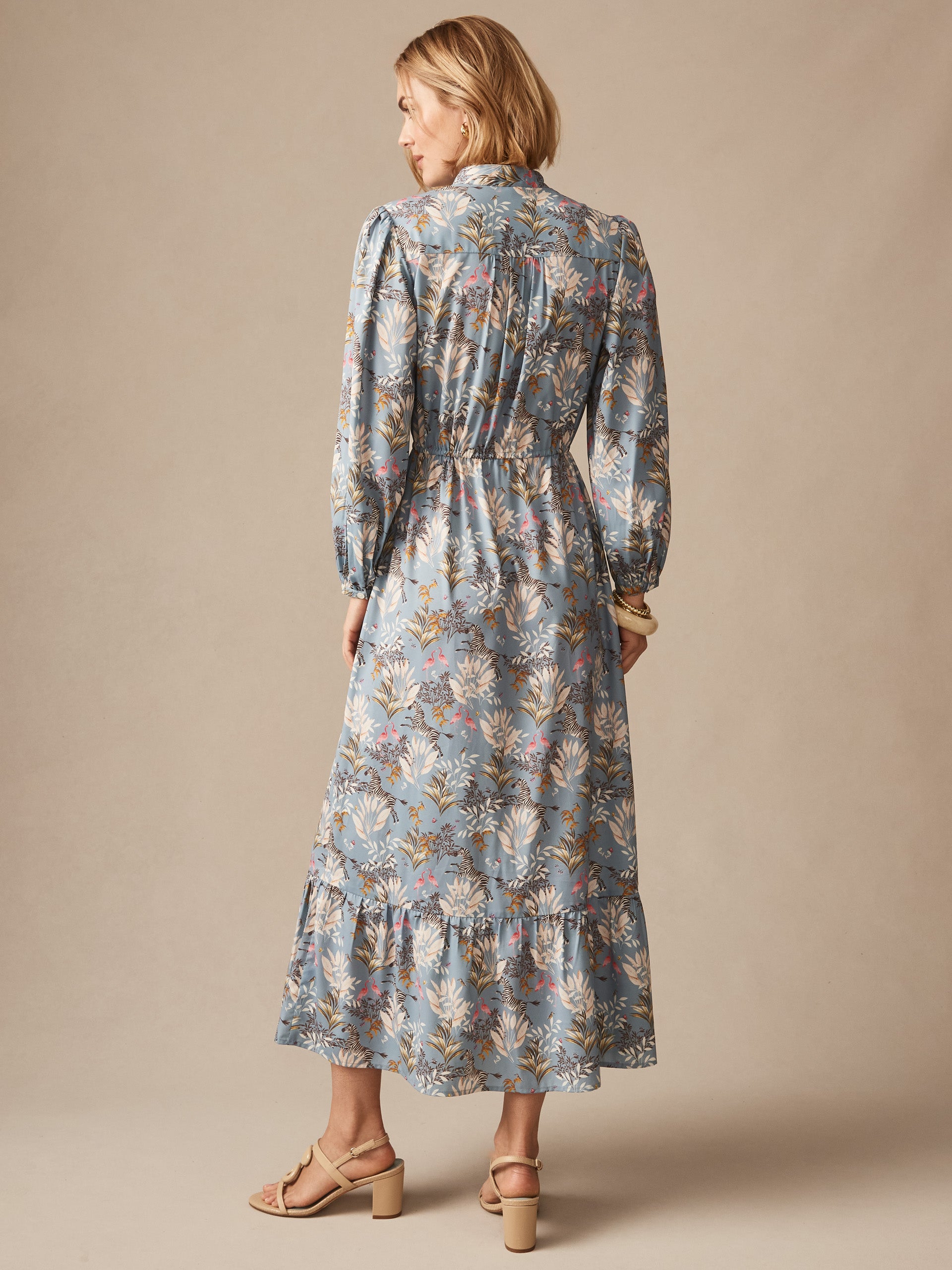 Woman wearing an Amrita Dress in Zebra Story by J.McLaughlin, featuring a delicate floral pattern in soft colors, showcasing effortlessly stylish, enduring designs with a legacy of timeless fashion. A destination for defining style. Life, Well-Lived.