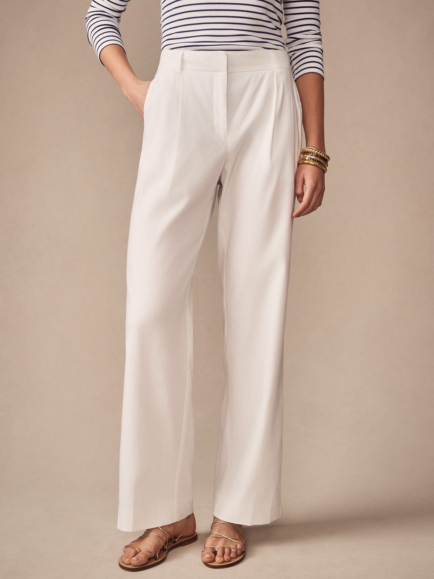 Woman wearing J.McLaughlin Fiona Linen Blend Pants in a classic cream shade paired with a striped top and gold bracelets, showcasing effortlessly stylish, enduring designs for a life well-lived.