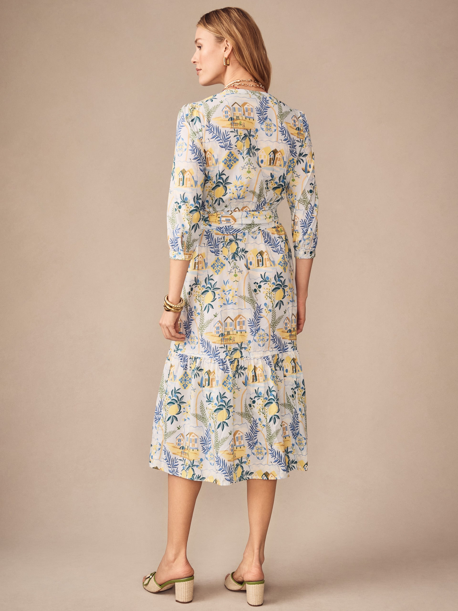 Woman wearing the Cerina Dress in Amalfi Coast by J.McLaughlin featuring a light blue and yellow patterned fabric, epitomizing effortlessly stylish and enduring designs with a legacy of timeless fashion. A destination for defining style. Life, Well-Lived.