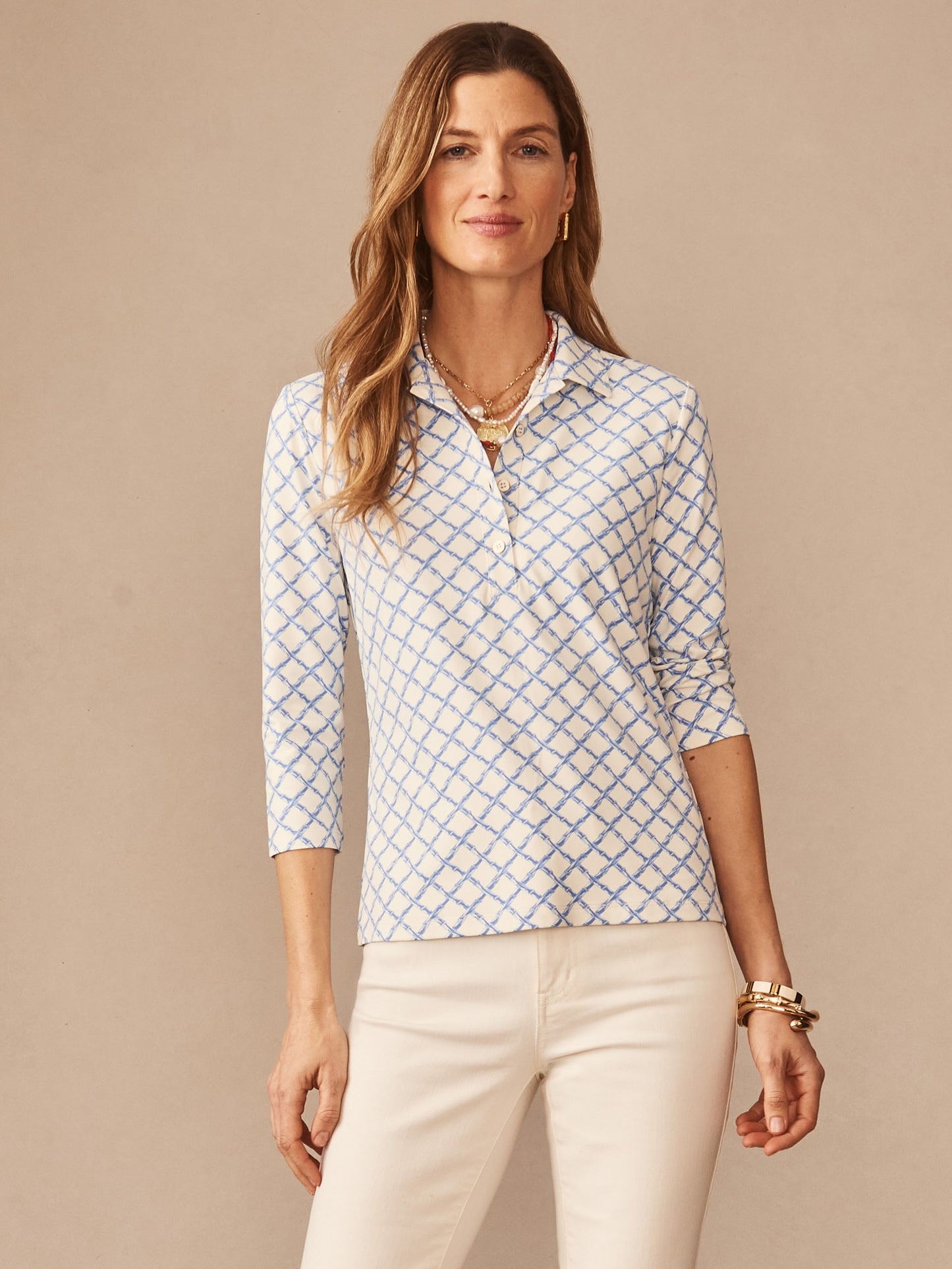 Woman wearing a J.McLaughlin Court 3/4 Sleeve Polo in Micro Bamboo with a subtle blue geometric pattern on an off-white background, embodying effortlessly stylish and enduring designs, crafted with innovative fabrics for a legacy of timeless fashion at a destination for defining style. Life, Well-Lived.
