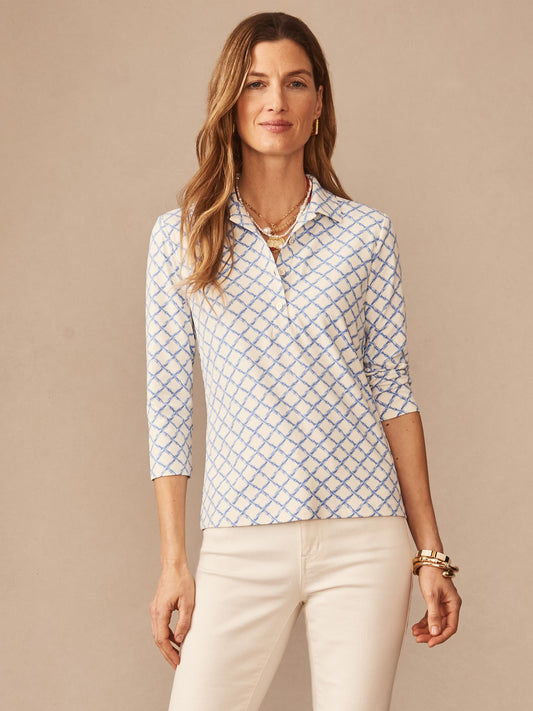 Woman wearing a J.McLaughlin Court 3/4 Sleeve Polo in Micro Bamboo with a subtle blue geometric pattern on an off-white background, embodying effortlessly stylish and enduring designs, crafted with innovative fabrics for a legacy of timeless fashion at a destination for defining style. Life, Well-Lived.