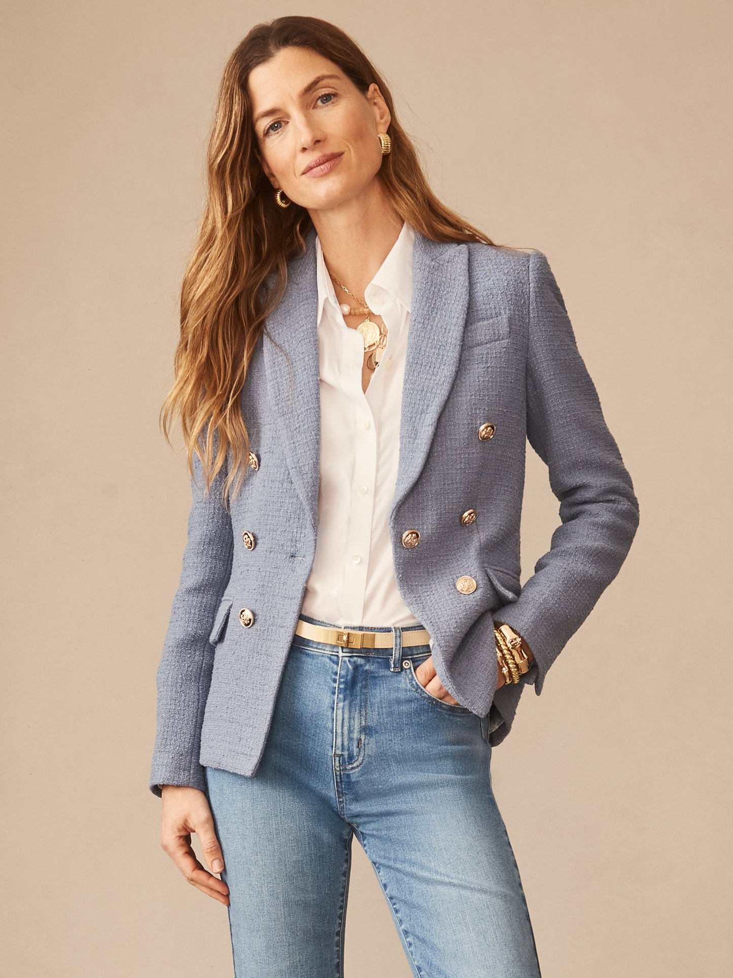 Woman wearing a frost blue Genevieve Cotton Bouclé Blazer by J.McLaughlin over a white blouse and jeans, showcasing effortlessly stylish, enduring designs and innovative fabrics.
