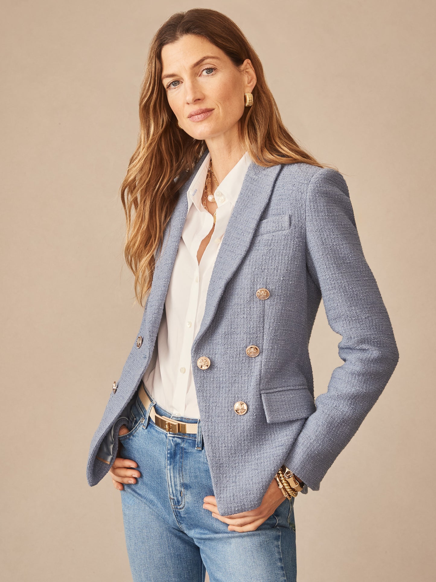 Woman wearing a Genevieve Cotton Bouclé Blazer from J.McLaughlin in a soft blue tone, paired with a white blouse and jeans, showcasing effortlessly stylish, enduring designs and innovative fabrics for a life well-lived.