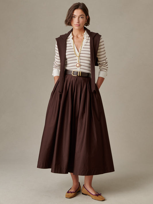 Woman wearing a brown Arabella Skirt by J.McLaughlin paired with a striped blouse, layered vest, belt, and flats, showcasing timeless, effortlessly stylish design.