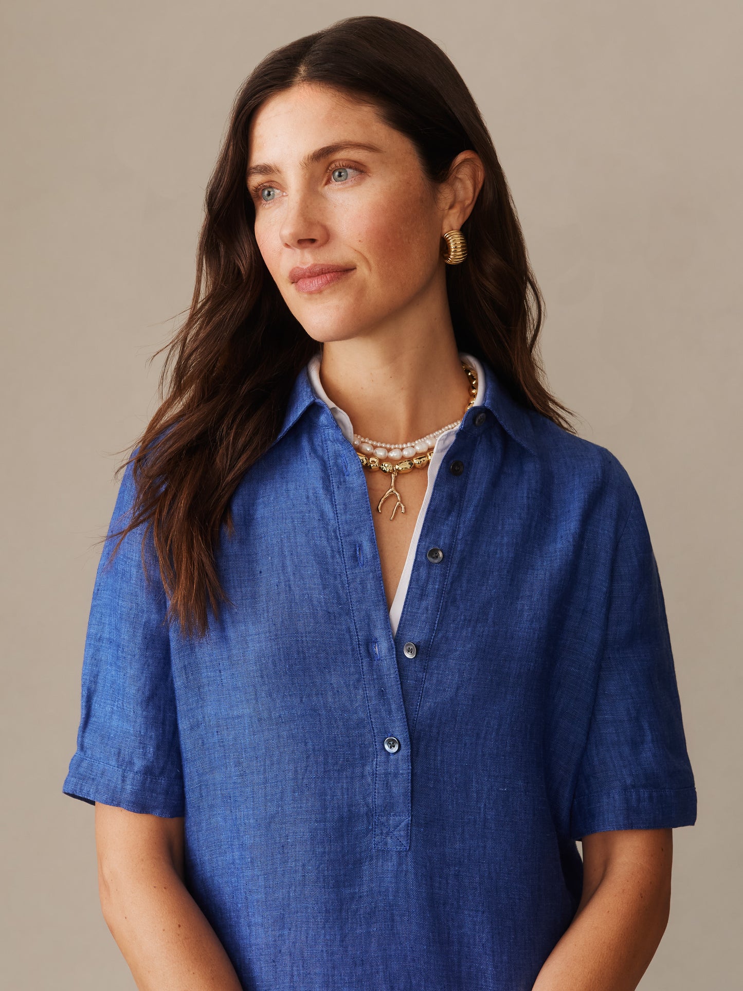 Woman wearing a denim blue Arissa Linen Dress by J.McLaughlin, showcasing effortlessly stylish, enduring designs crafted from innovative fabrics for a legacy of timeless fashion.