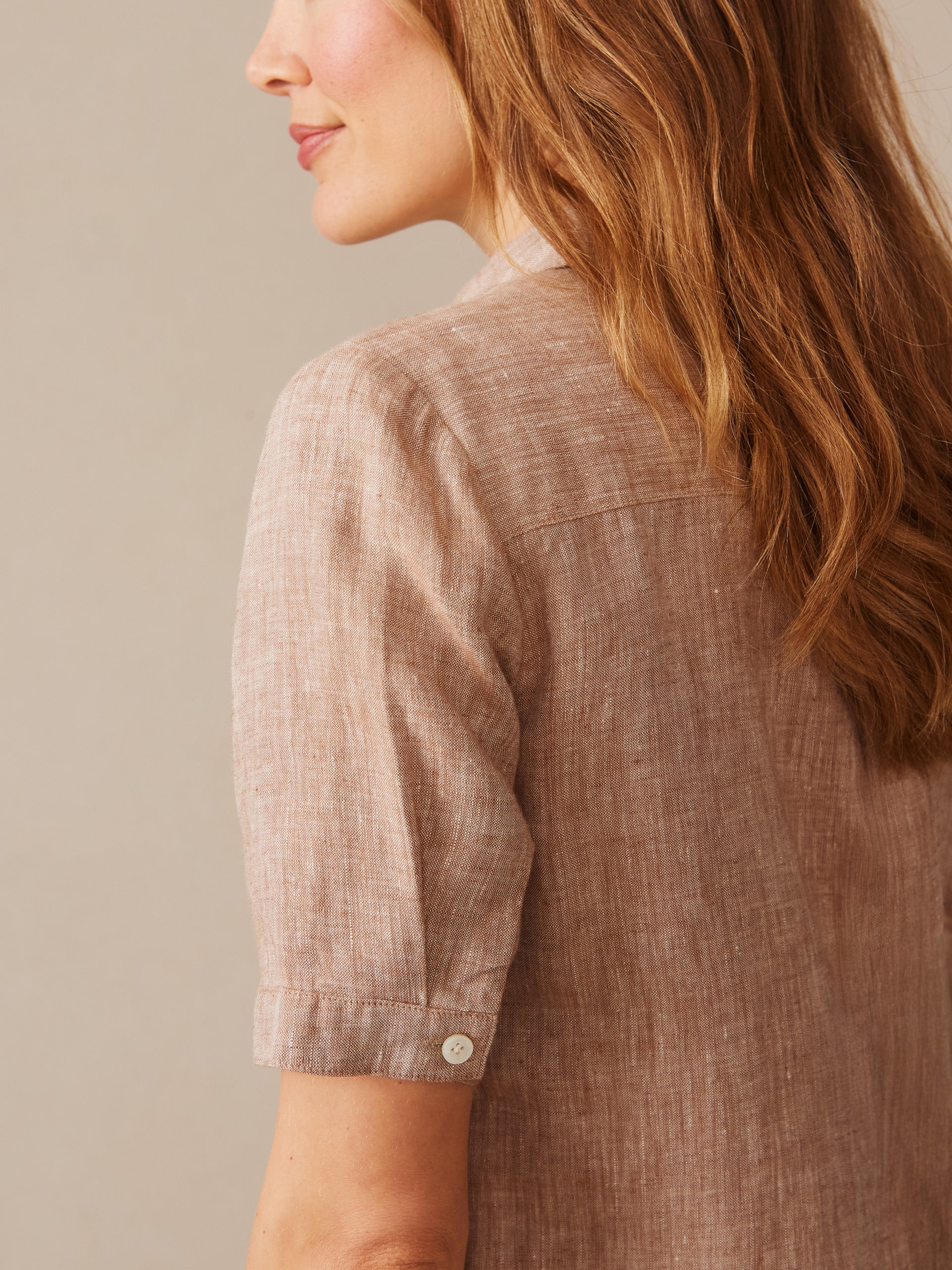Close-up of a woman wearing the Arissa Linen Dress by J.McLaughlin in a soft latte color, showcasing the breathable linen fabric and timeless, effortlessly stylish design for enduring appeal.