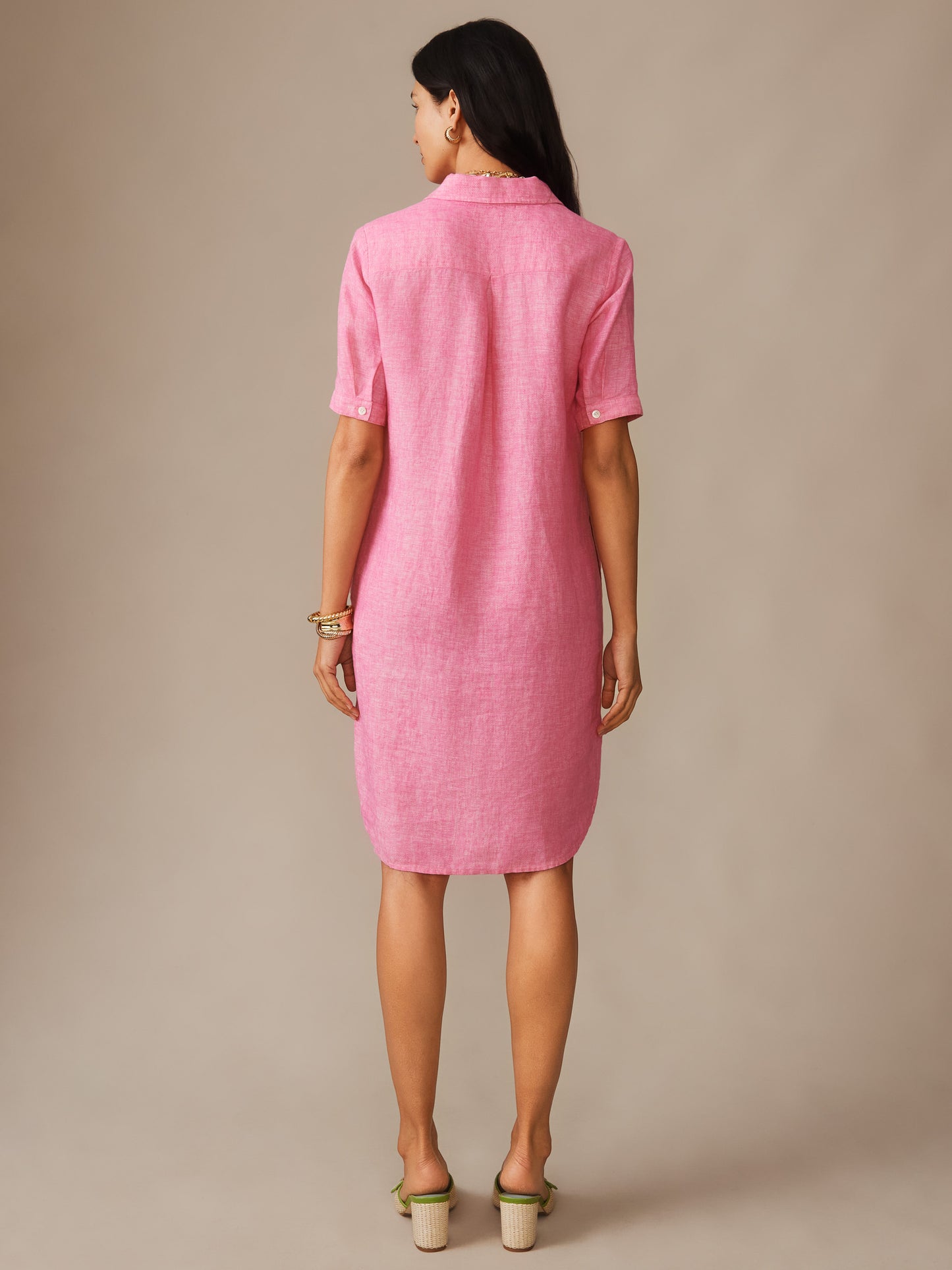 A woman models the Arissa Linen Dress in soft pink by J.McLaughlin, showcasing its effortlessly stylish, enduring design crafted from innovative linen fabric—a destination for defining style. Life, Well-Lived.