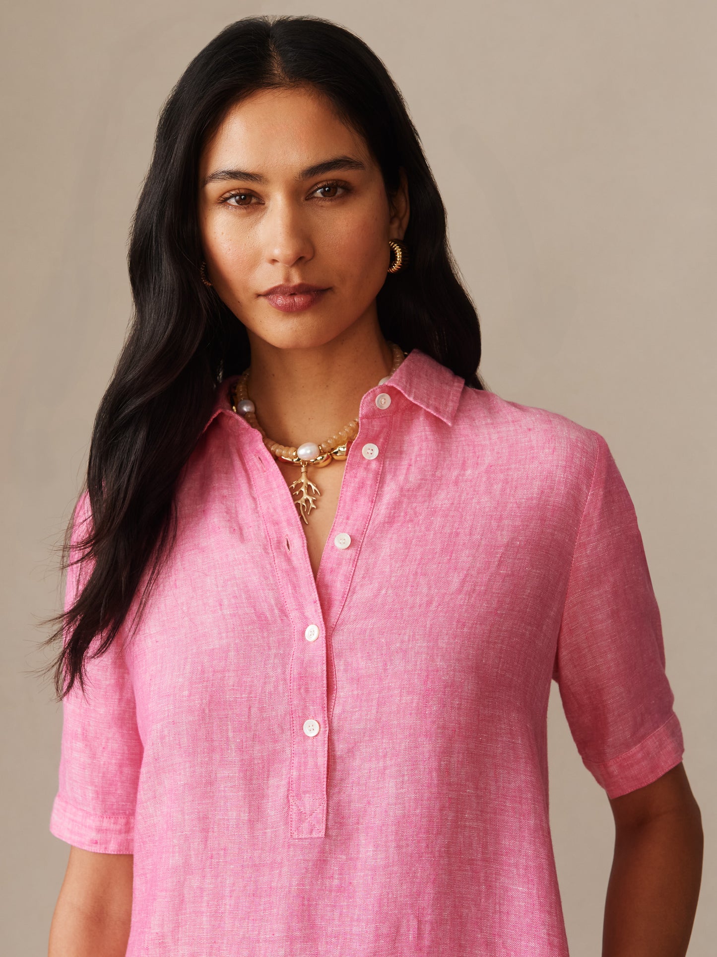 Woman wearing a bright pink Arissa Linen Dress by J.McLaughlin, showcasing effortlessly stylish and enduring designs made with innovative fabrics, capturing a legacy of timeless fashion.