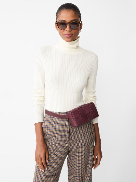 Model wearing J.McLaughlin Arlette turtleneck in egret white made with cotton/modal.