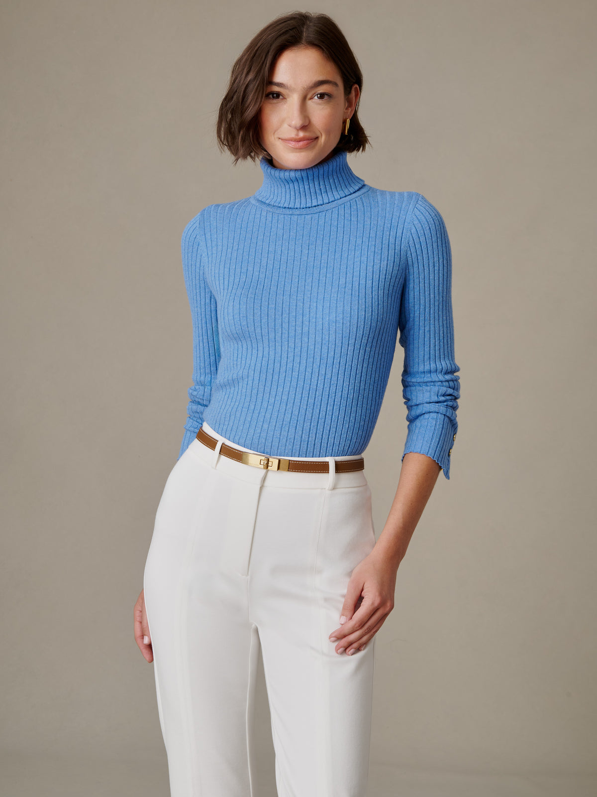 J.McLaughlin Arlette Turtleneck in blue ribbed stretch cotton modal styled with white trousers and a belt on a model
