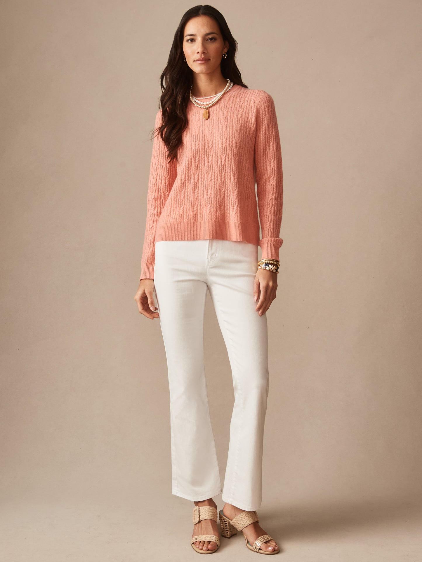 Woman wearing an effortlessly stylish Ashby Cashmere Sweater in soft coral paired with white pants and sandals, showcasing enduring designs by J.McLaughlin, a destination for defining style. Life, Well-Lived.