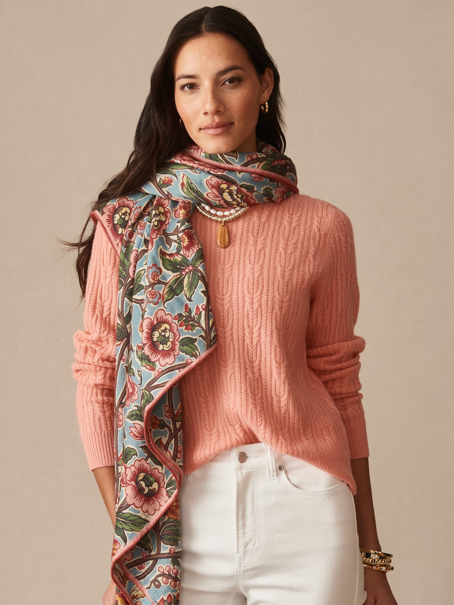 Woman wearing Vanessa Scarf in Bucolic Blooms Border by J.McLaughlin styled with a coral sweater and white pants, showcasing effortlessly stylish scarves with enduring designs.