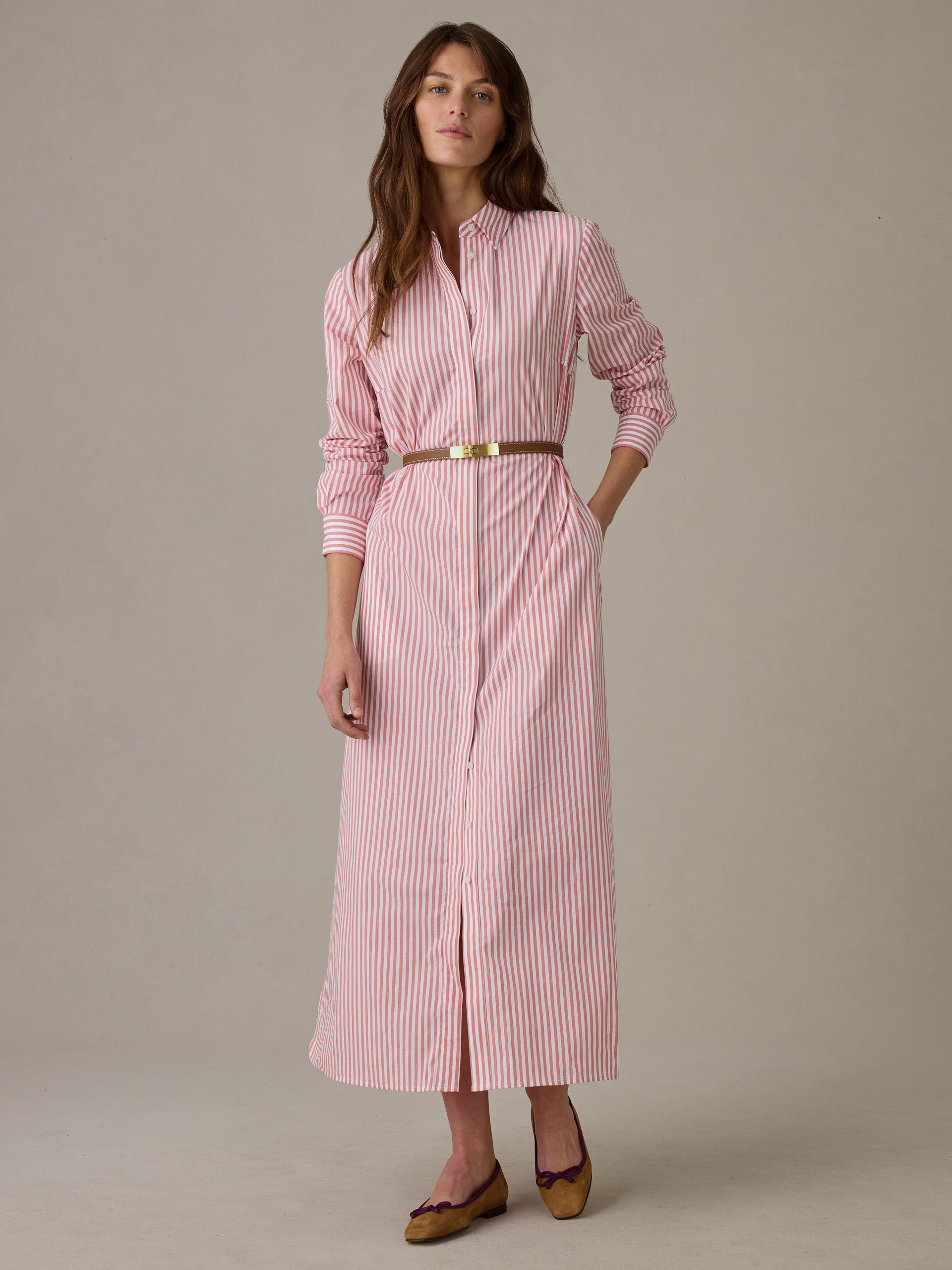 Woman wearing a J.McLaughlin Leighton Dress in Stripe with a brown belt and matching flats, showcasing effortlessly stylish and enduring design for a timeless look.
