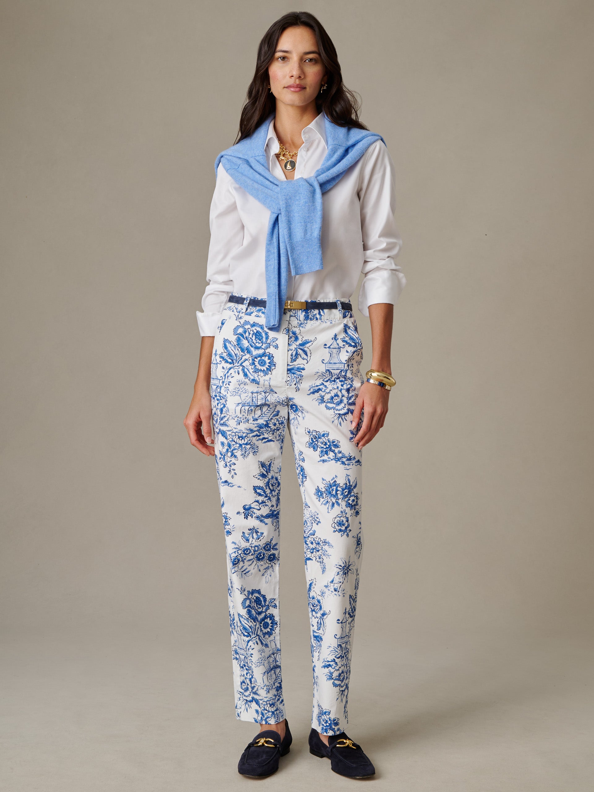 Woman wearing Avery Pants in Antique Toile by J.McLaughlin, styled with a white blouse and light blue sweater draped over shoulders, showcasing effortlessly stylish, enduring design.