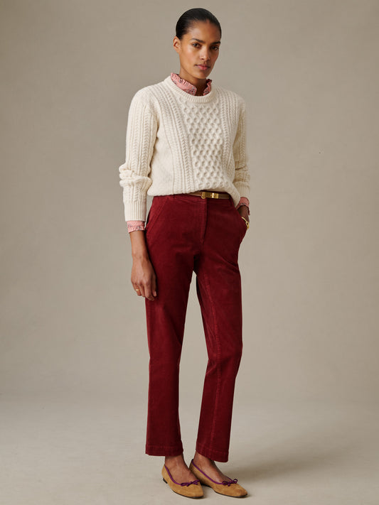 Woman wearing burgundy Avery Corduroy Pants by J.McLaughlin paired with a cream cable-knit sweater and loafers, showcasing effortlessly stylish and enduring designs.
