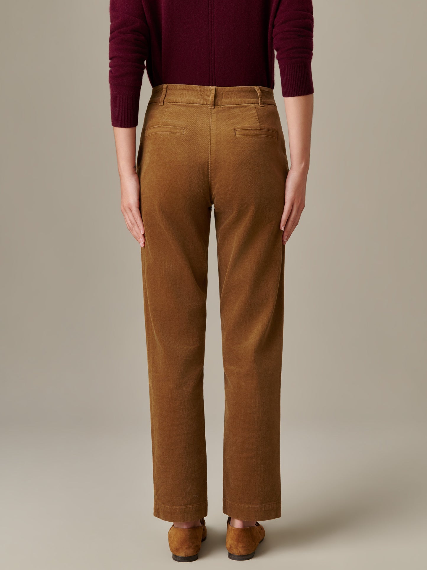Back view of a person wearing Avery Corduroy Pants by J.McLaughlin in a rich brown shade paired with a burgundy top, showcasing a timeless, effortlessly stylish design.