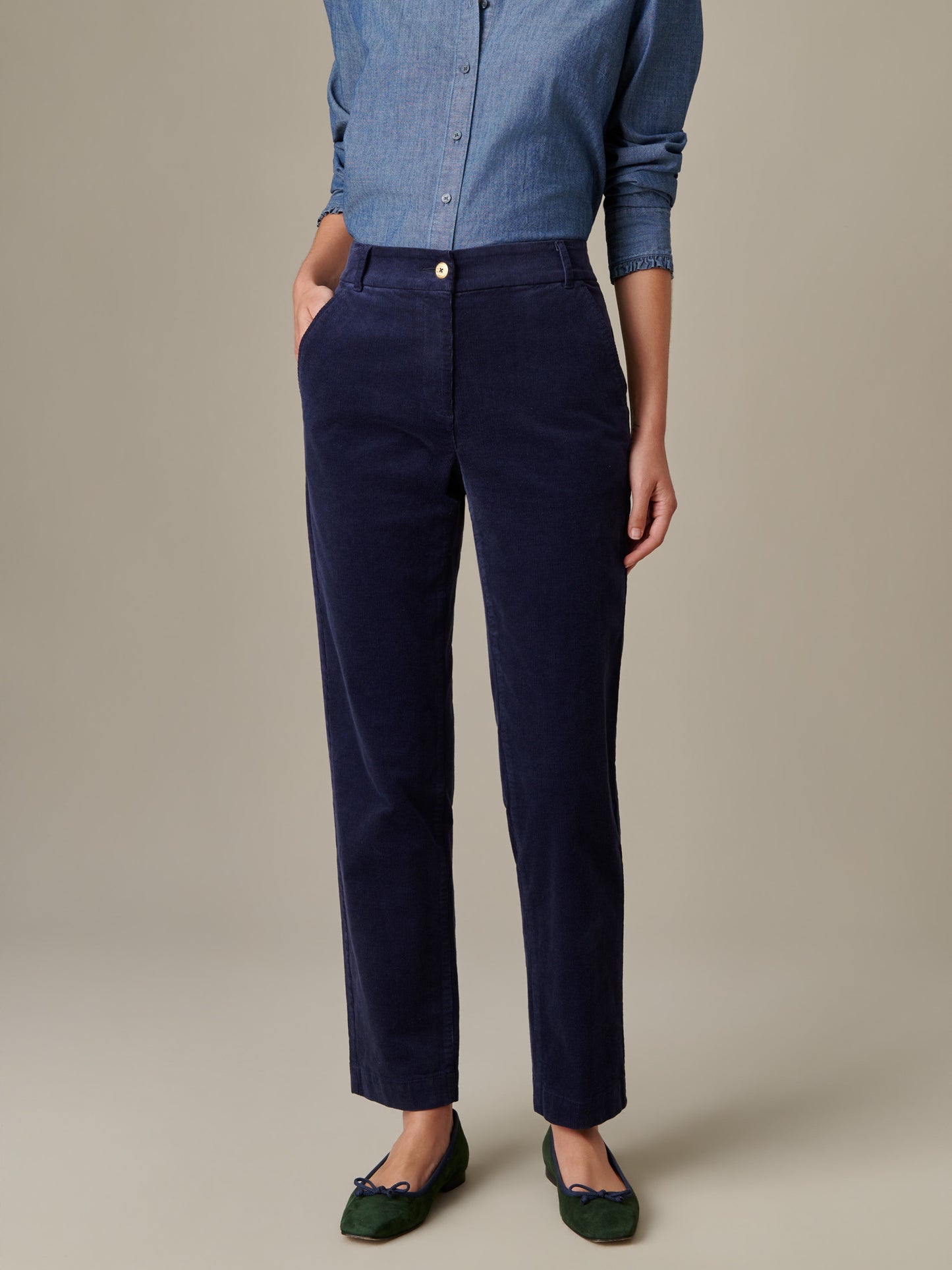 Model wearing navy Avery Corduroy Pants styled with a chambray shirt and green flats, showcasing J.McLaughlin’s effortlessly stylish, enduring design and classic craftsmanship.