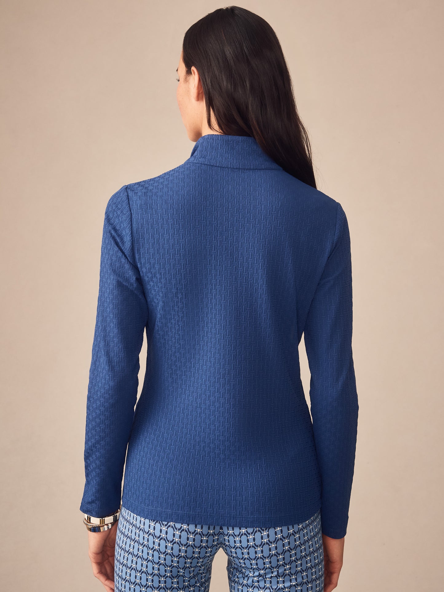 Woman modeling the Bedford Top in Dashing Jacquard by J.McLaughlin, showcasing effortlessly stylish, enduring designs with innovative fabric in a timeless navy blue. A destination for defining style. Life, Well-Lived.
