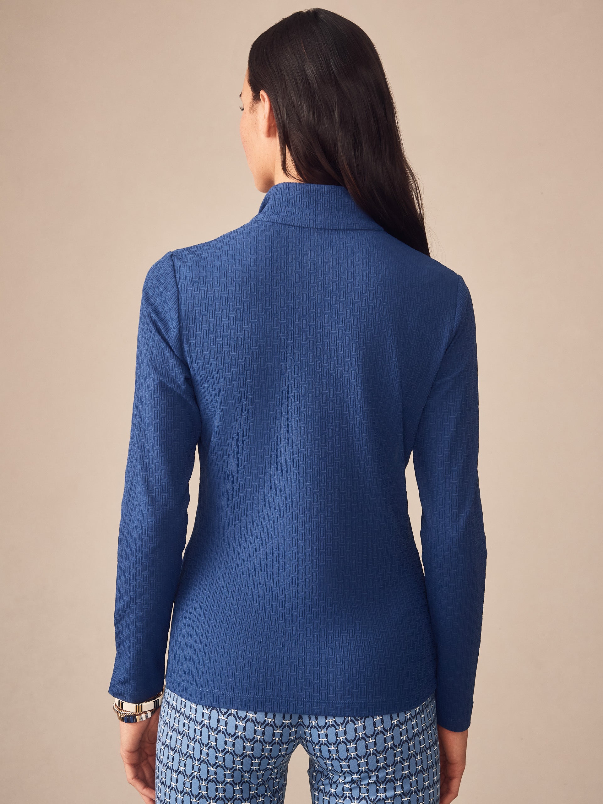 Woman modeling the Bedford Top in Dashing Jacquard by J.McLaughlin, showcasing effortlessly stylish, enduring designs with innovative fabric in a timeless navy blue. A destination for defining style. Life, Well-Lived.