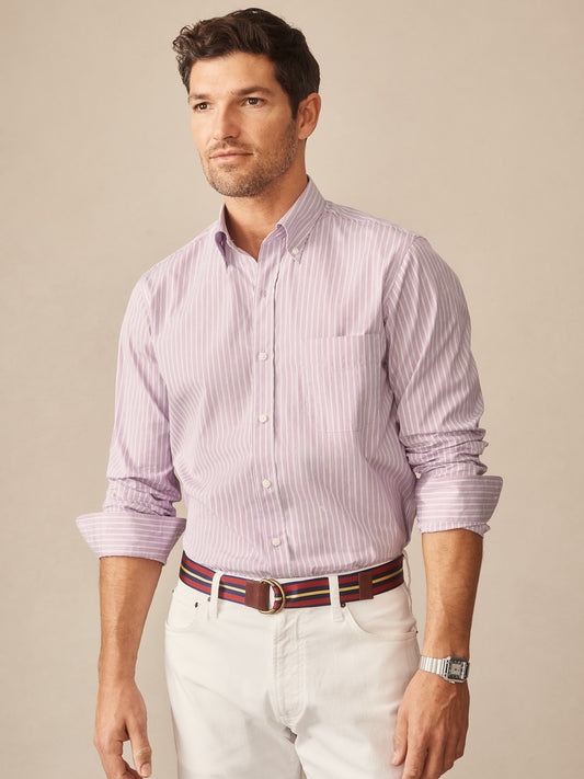 Man wearing a Belvedere Cotton Shirt in Multi Stripe by J.McLaughlin, featuring soft cotton fabric with purple and blue stripes, paired with white pants and a striped belt, showcasing effortlessly stylish, enduring designs and innovative fabrics for a legacy of timeless fashion. A destination for defining style. Life, Well-Lived.
