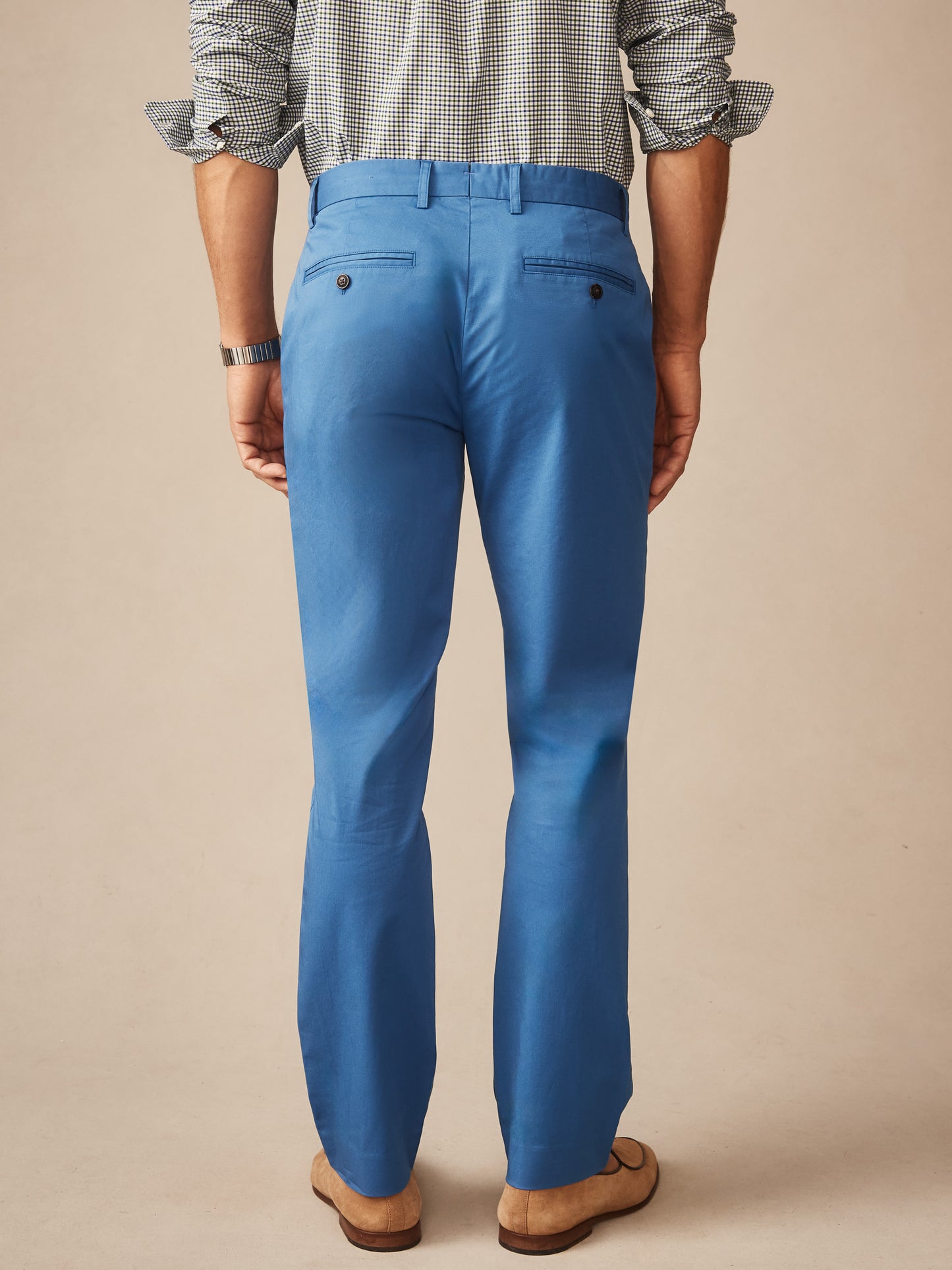 Back view of a man wearing J.McLaughlin Madison Pants in blue paired with a checkered shirt, showcasing effortlessly stylish design and enduring quality for a life well-lived.