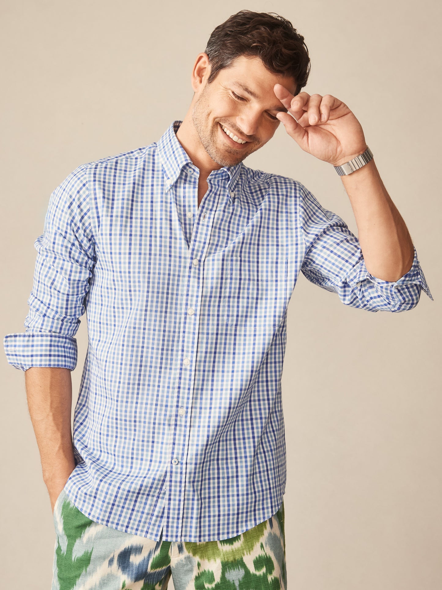 A man wearing the Belvedere Cotton Shirt in Gingham Multi by J.McLaughlin, showcasing an effortlessly stylish, classic blue and white gingham pattern that reflects enduring designs and a legacy of timeless fashion.