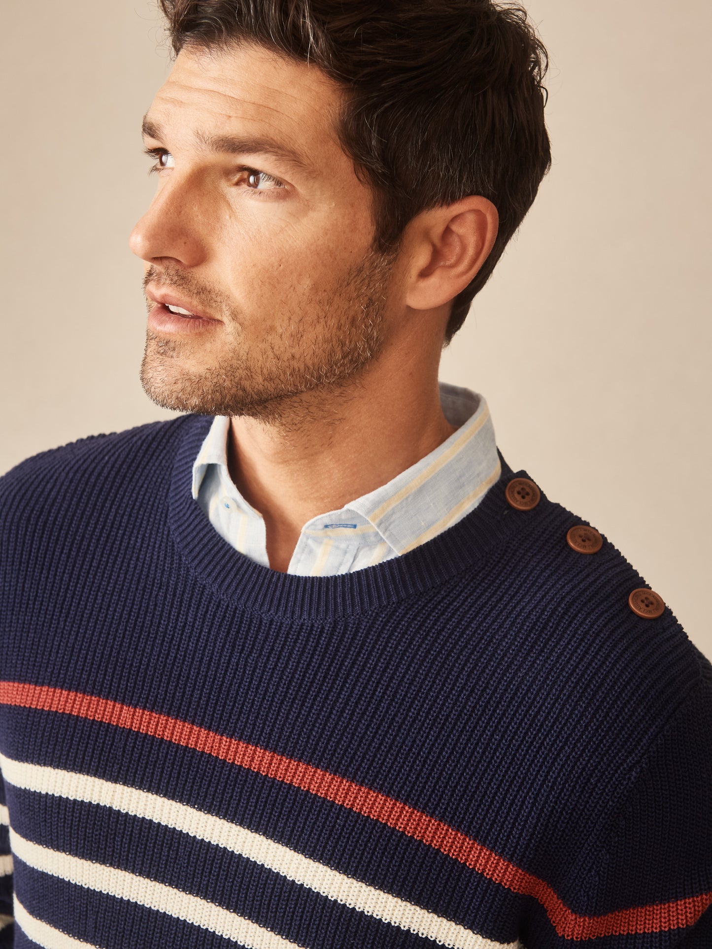 Man wearing a navy blue Bennett Sweater in Stripe by J.McLaughlin, featuring classic button details and a refined striped pattern, exemplifying effortlessly stylish, enduring designs with innovative fabrics for a legacy of timeless fashion. A destination for defining style. Life, Well-Lived.