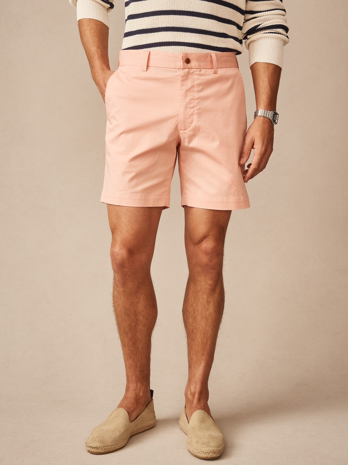 A man wearing blush pink Chatham Shorts by J. McLaughlin paired with a striped sweater and slip-on shoes, showcasing effortlessly stylish, enduring designs with a legacy of timeless fashion. A destination for defining style. Life, Well-Lived.