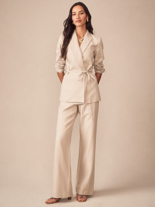 Woman wearing J.McLaughlin Blythe Linen Blend Pants in a sand color with a matching belted blazer, embodying effortlessly stylish, enduring designs with innovative fabrics for a legacy of timeless fashion.
