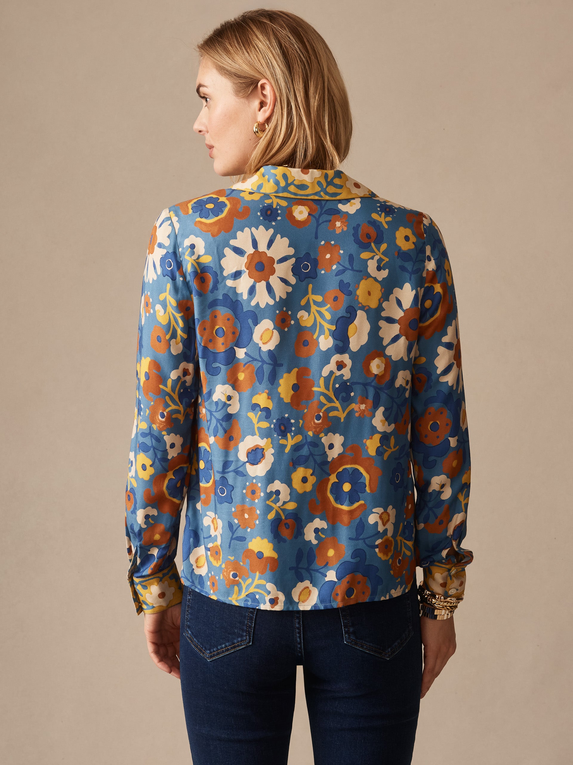 Woman seen from the back wearing a Bimini Shirt in Floral Daydream Edge by J.McLaughlin, featuring a colorful floral pattern on an effortlessly stylish shirt, embodying enduring designs and a legacy of timeless fashion. A destination for defining style. Life, Well-Lived.