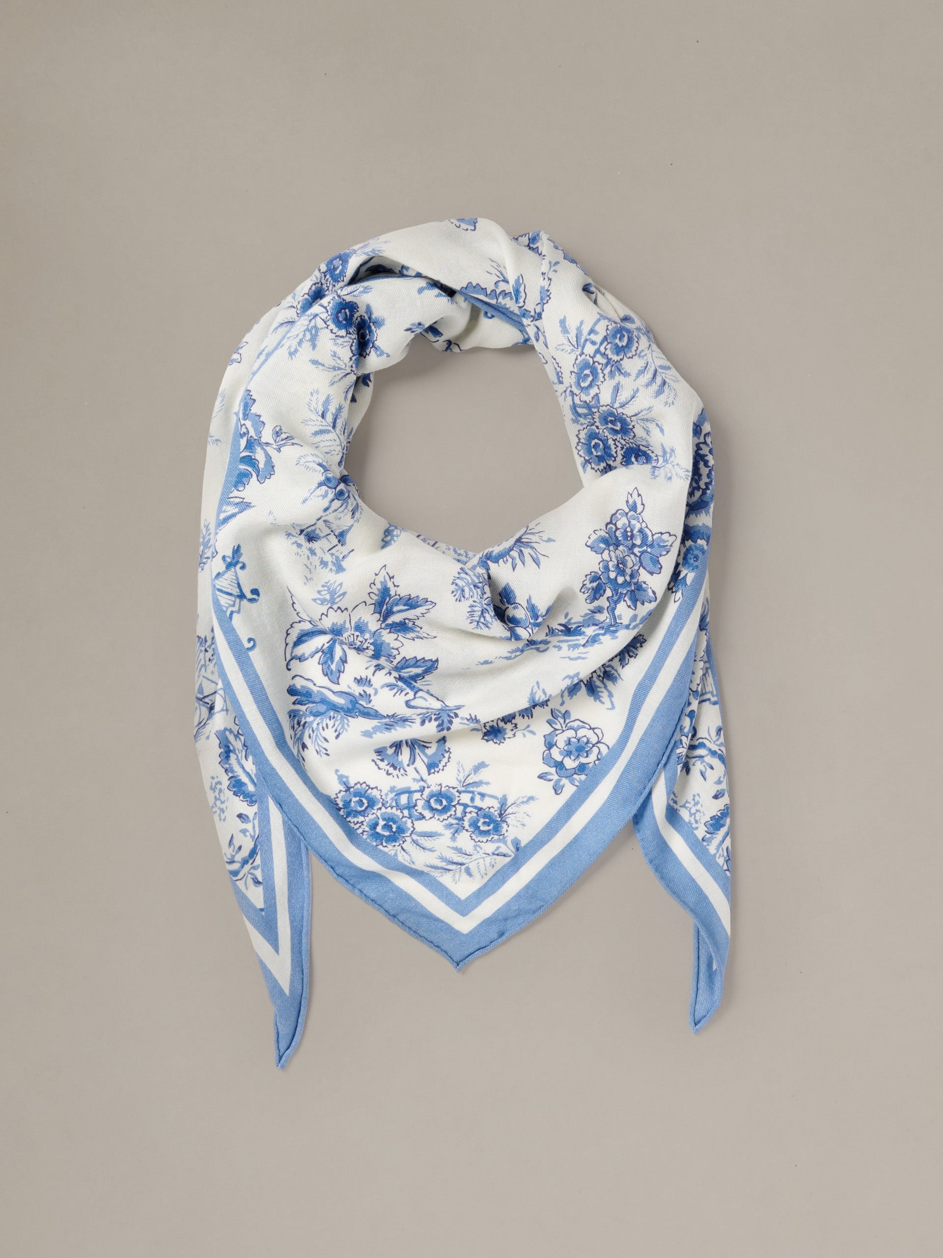 The Blair Scarf in Antique Toile Corner by J.McLaughlin featuring a blue and white floral pattern in a lightweight triangular design for elegant styling