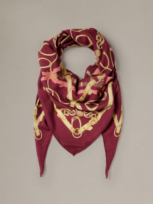 The Blair Scarf in Grand Heraldic Corner by J.McLaughlin is a burgundy and gold patterned triangular scarf with a soft luxurious drape