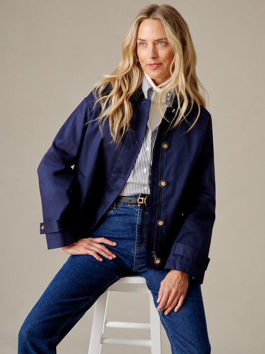 J.McLaughlin Brantley Jacket in navy styled with a striped shirt and jeans on a seated woman showcasing refined classic design