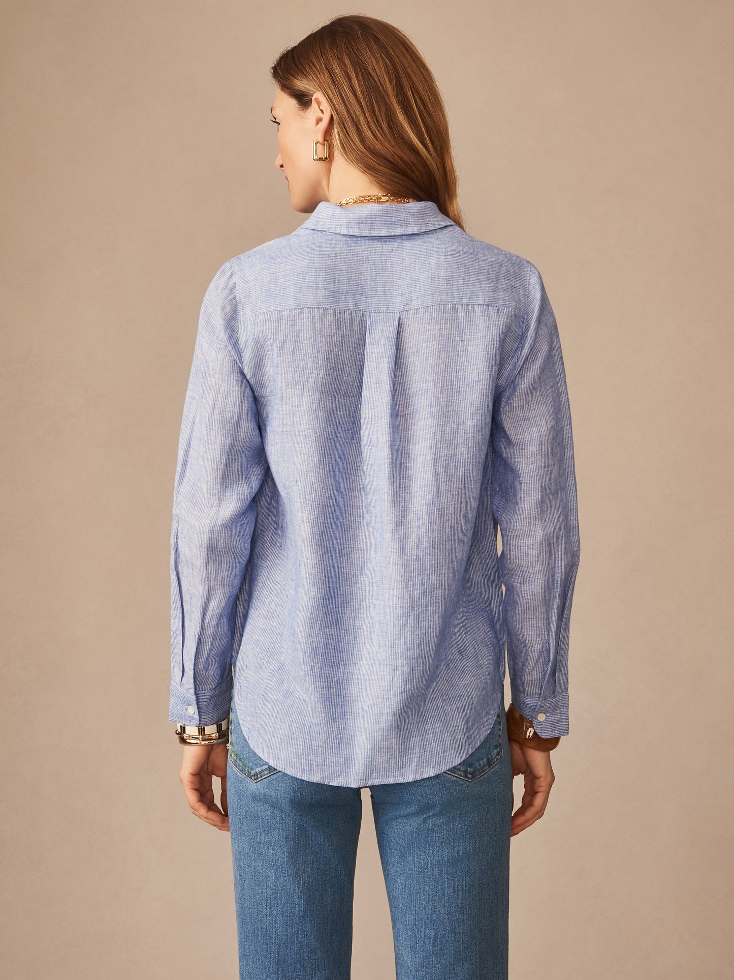 Woman wearing Britt Linen Shirt in Stripe by J.McLaughlin, showcasing effortlessly stylish design and enduring fabrics, embodying a legacy of timeless fashion and a destination for defining style. Life, Well-Lived.