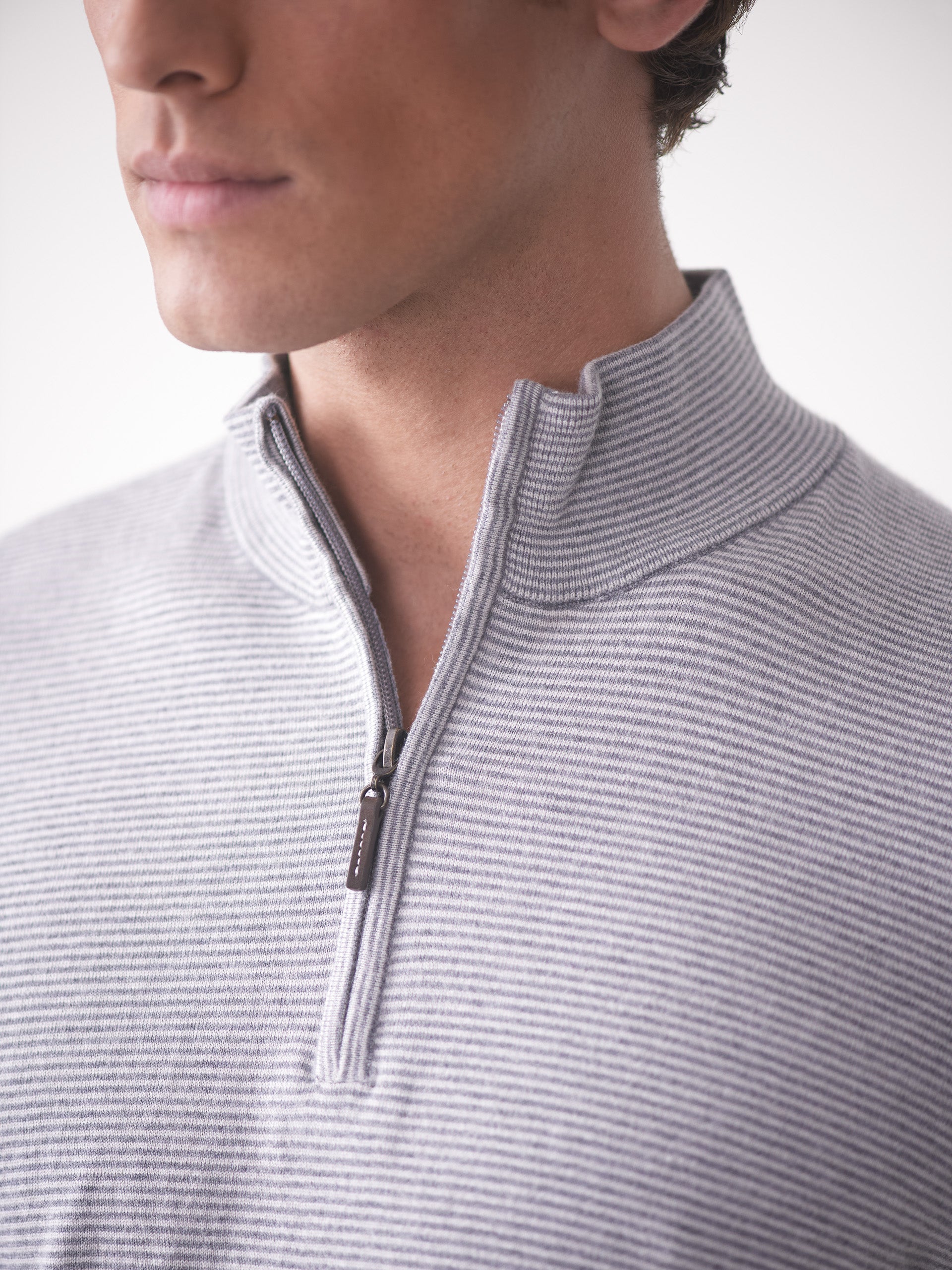 Model wearing J.McLaughlin Brookhaven sweater in gray/light gray made with cotton, viscose, nylon, and cashmere.