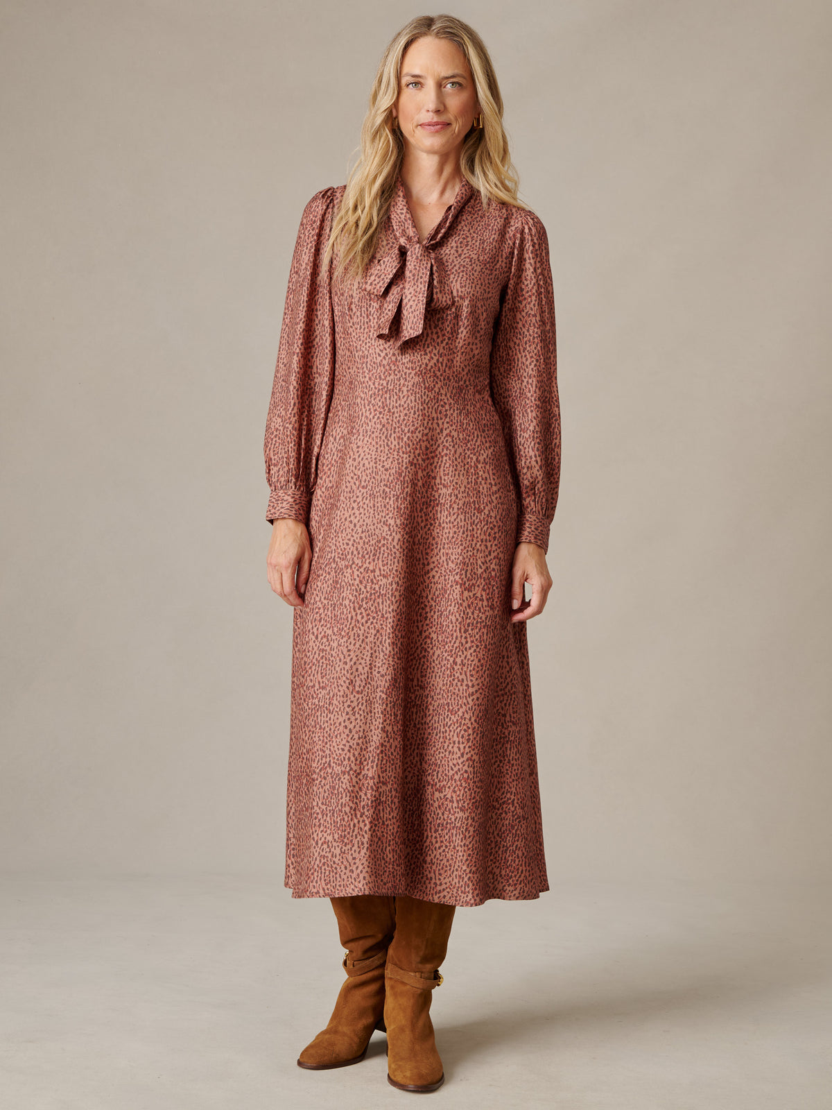 Cally Silk Blend Dress in Leopardette by J.McLaughlin on model with long blouson sleeves and scarf necktie styled with tall brown boots