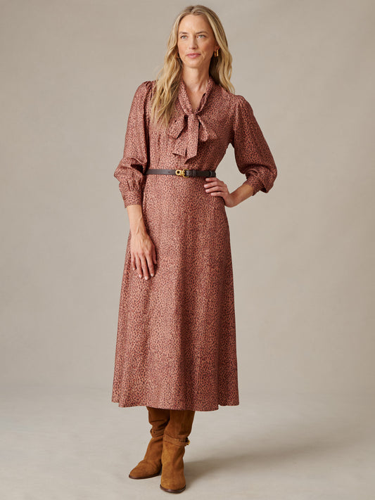 Cally Silk Blend Dress in Leopardette with tied scarf neckline blouson sleeves and belted waist styled with tall boots by J.McLaughlin