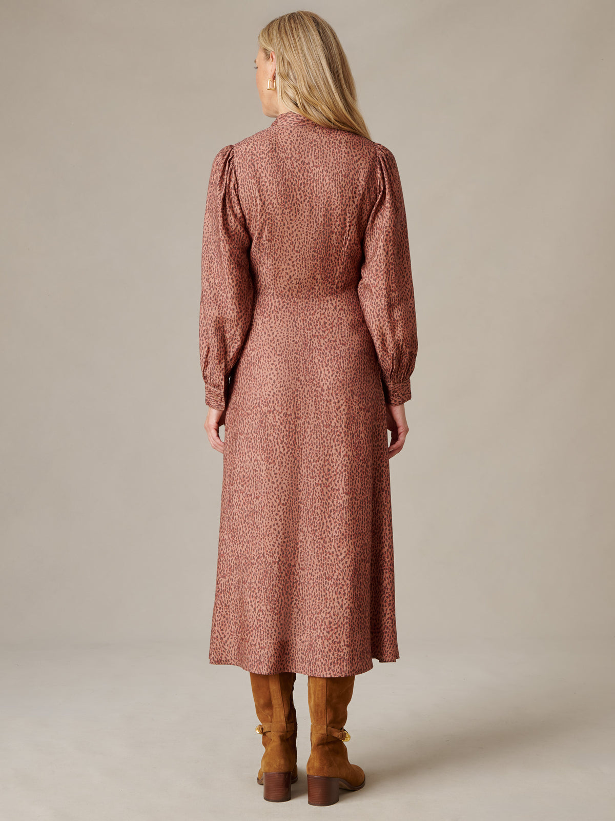 Back view of a model wearing the Cally Silk Blend Dress in Leopardette by J.McLaughlin featuring a fluid leopard print silhouette long blouson sleeves and midi length