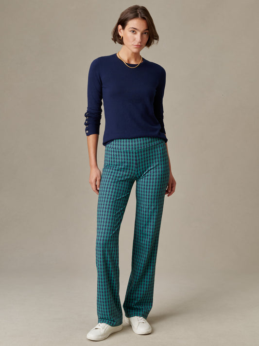 Woman wearing J.McLaughlin Carmel Pants in Algiers Check with a navy blue long-sleeve top and white sneakers, showcasing effortlessly stylish, enduring designs.