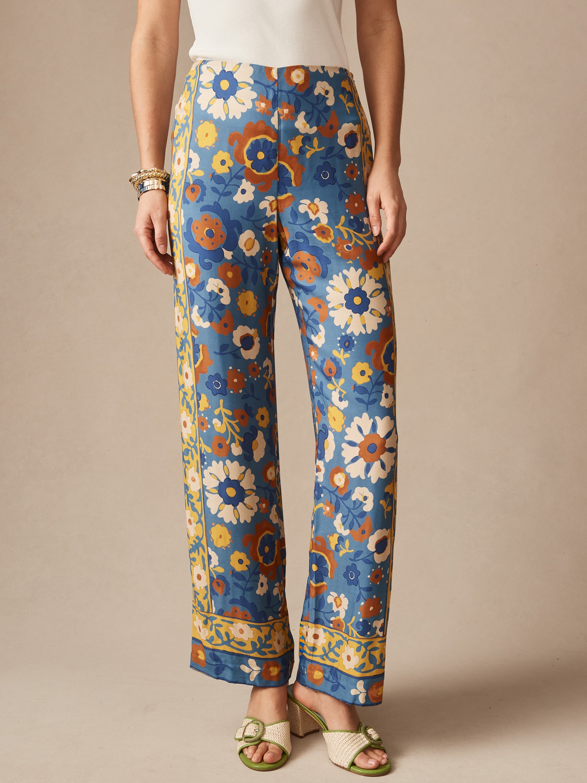 A pair of Carter Silk Blend Pants in Floral Daydream Edge by J.McLaughlin featuring an effortless floral print in blue, yellow, and brown tones, exemplifying enduring designs and innovative fabrics for a life well-lived.