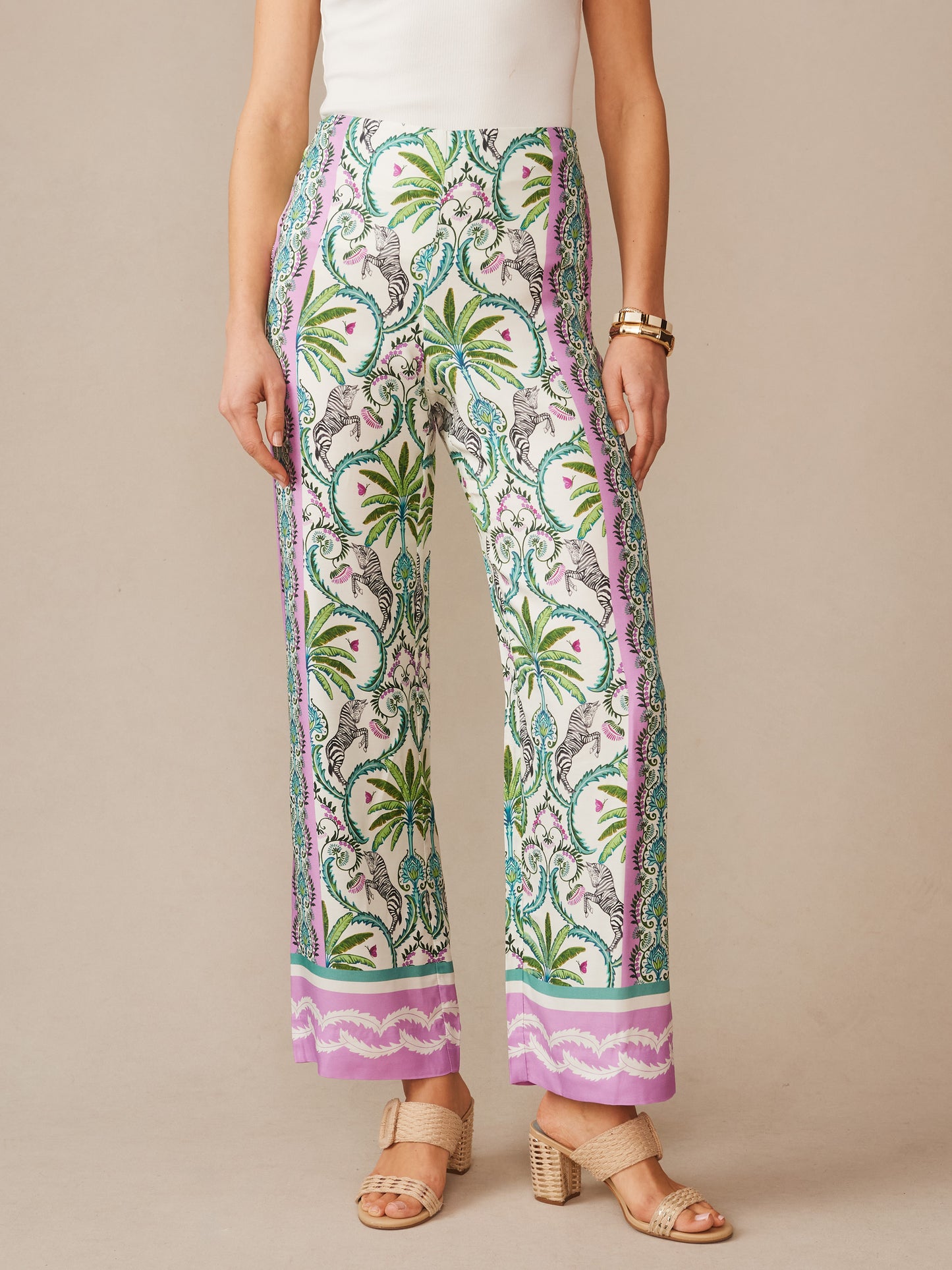 A woman wearing J.McLaughlin Carter Silk Blend Pants in Zebra Isle Edge featuring an intricate botanical and zebra pattern with lavender, green, and white tones, embodying effortlessly stylish, enduring designs and innovative fabrics. A destination for defining style. Life, Well-Lived.