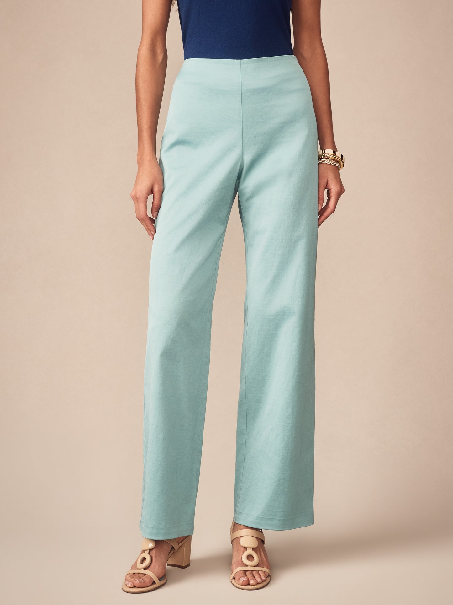 Woman wearing seafoam green Carter Dupioni Cotton Pants from J.McLaughlin paired with a navy top and stylish sandals, showcasing effortlessly stylish, enduring designs and innovative fabrics.